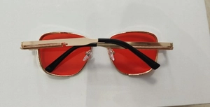 Detail of red lenses and gold metal frames with steampunk spring temple design