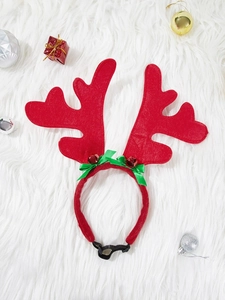 Close-up of reindeer antler headband for dogs with bells and bow on white fur background