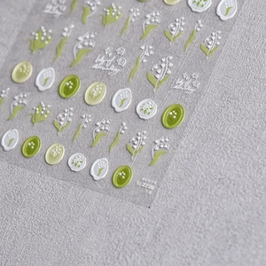 Detailed view of Lily of the Valley embossed nail stickers with green floral patterns
