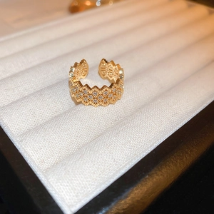 Macro detail of gold plated dragon ring with cubic zirconia on white display box