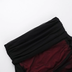 Detail of red and black mesh dress featuring layered ruffles and textured pleats