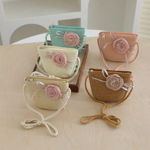 Detail of five mini woven straw bags with fabric roses and zipper closures for girls