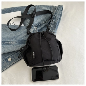 Detail der schwarzen Nylon-Beuteltasche mit seitlicher Netztasche und verstellbarem Gurt
