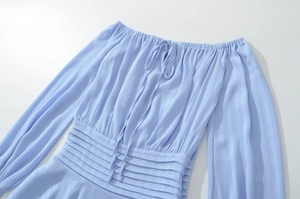 Détail de la robe bleu clair à épaules dénudées avec texture plissée et taille élastique