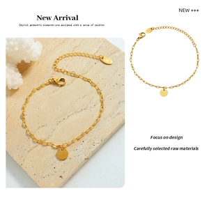 Detail of 18k gold plated minimalist chain bracelet with polished round disc charm