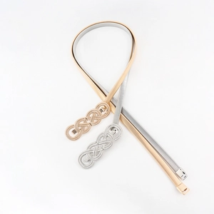Detailed shot of elastic metal waist chains in gold and silver with infinity knot buckles