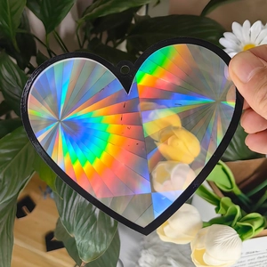 Macro shot of heart-shaped holographic prism suncatcher with rainbow diffraction light