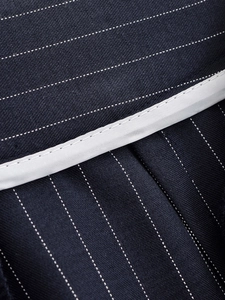 Vue macro détaillée du tissu bleu marine à fines rayures avec coutures blanches de qualité
