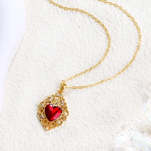 Macro detail of red heart ruby pendant with gold hollow crown setting and zircon inlay