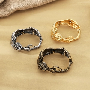 Macro detail of antique gold tiger head stainless steel bracelet showing metal texture