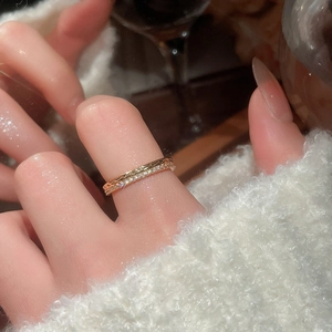 Close-up of stacked 18k gold plated rings with zircon stones and wave texture design