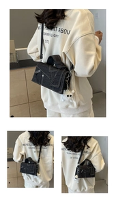 Détails du sac bandoulière en denim gris foncé avec coutures contrastées et breloque