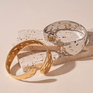 Bracciali aperti in metallo oro e argento con un design organico e strutturato