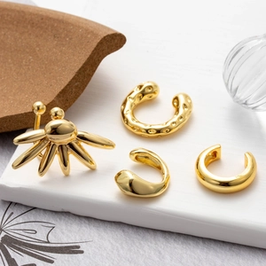 Set of four gold non-piercing ear cuffs with textured and minimalist floral designs