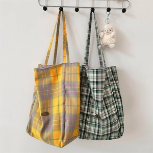 Detailed close-up of large check canvas tote bags in yellow and green plaid patterns