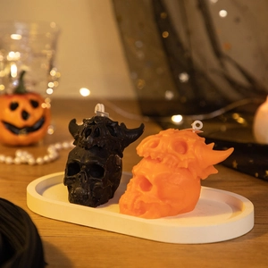 Halloween skull aromatherapy candles in black and orange set on a white tray with pumpkin lights