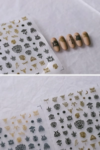 Detail of gothic and bohemian embossed nail stickers in gold and black with mystic motifs