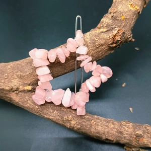 Macro shot of a star-shaped hair clip with pink natural crystal stones on a wooden branch