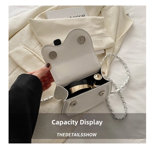 Internal capacity of white saddle bag showing space for lipstick and makeup compact