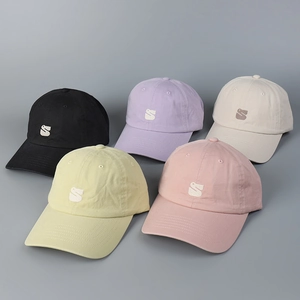 Detail of embroidered duck and S logo on breathable cotton baseball caps in five pastel colors