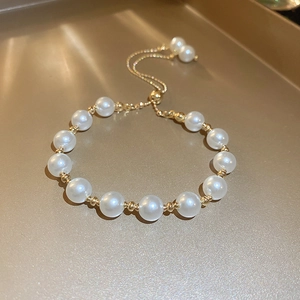 Detail of adjustable French vintage pearl bracelet with gold beads and bolo closure