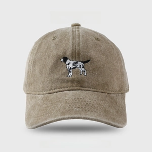 Detail showing high-quality embroidery of a pointer dog on a khaki washed denim baseball cap