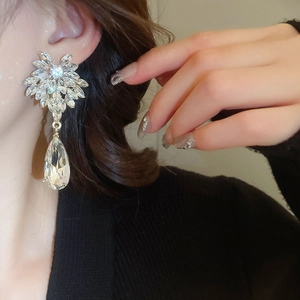 Gros plan de boucles d'oreilles pendantes en argent avec gouttes et cristaux étincelants