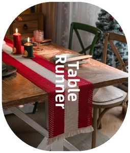 Close-up of red and beige knitted Christmas table runner with festive tassel fringe detail