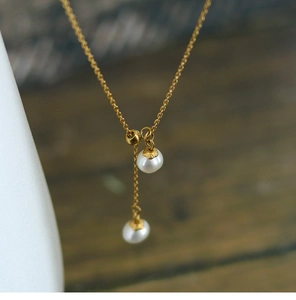 Macro detail of French style gold-plated necklace with natural freshwater pearl tassels