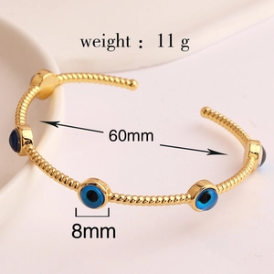 Gold plated open bangle featuring a blue evil eye charm and clear dimensions