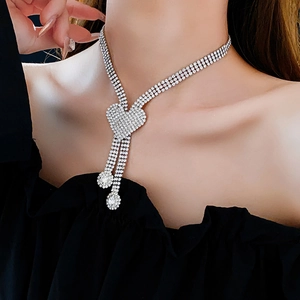 Close-up of a silver multi-layered rhinestone necklace with heart pendant on model