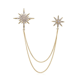 Elegant gold double star brooch with crystal inlay and chain link on white background