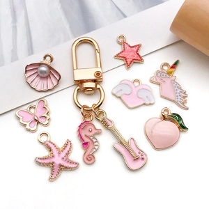 Pink enamel charms and gold keychain set featuring unicorn, butterfly and sea shell shapes