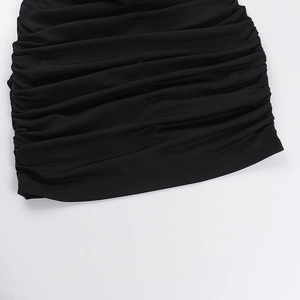 Close-up of black ruched fabric texture on a halter neck bodycon mini dress