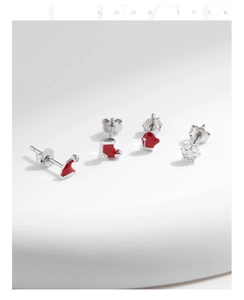 Detail view of S925 sterling silver Christmas earrings with red enamel hat and snowflake shapes