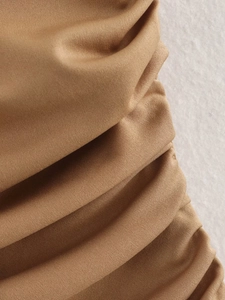 Details von gerafftem Strickstoff in Hellbraun mit elegantem Faltenwurf
