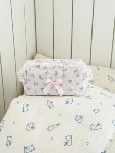 Floral quilted makeup bag with pink bow and lace trim on a white background