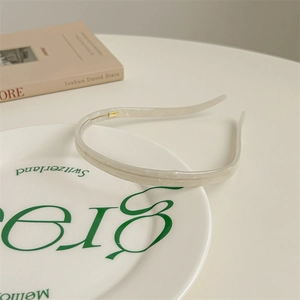Detail van witte acetaat haarband met marmertextuur en antislip tanden op bord