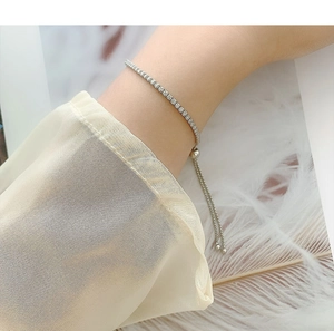Close-up of adjustable silver tennis bracelet with white zircons on model wrist