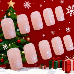 Pink Christmas press-on nails with white snowflake and bow designs on festive background