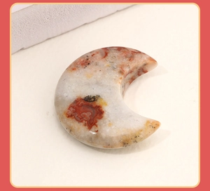 Close-up of polished moon-shaped natural agate stone with red-brown and white texture