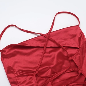Detail of red satin evening gown featuring criss-cross back straps and smooth texture