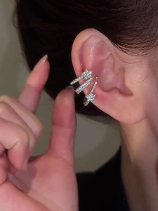 Close-up of a silver-tone multi-layer star ear cuff with sparkling zircon on a model