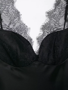Gros plan sur la dentelle cil élégante et la texture satinée lisse du caraco noir