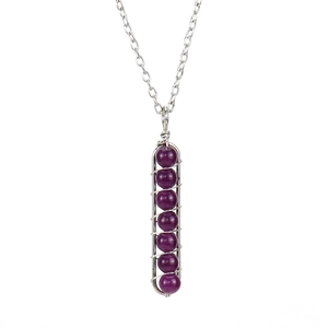 Detail of handmade silver wire wrapped pendant with seven purple crystal beads on necklace