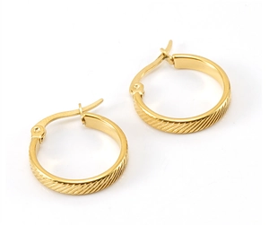 Macro shot of 18K gold plated hoop earrings featuring intricate diagonal textured engraving