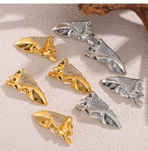 Detailed view of abstract molten metal brooches in gold and silver with crystal accents