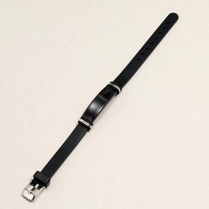 Bracciale minimalista in silicone nero con fibbia in acciaio inossidabile su sfondo beige