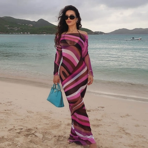 Detail of sheer striped mesh long dress with pink and purple tones at beach
