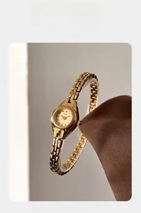 Détail de la montre GEDI vintage à chaîne dorée avec mini cadran tonneau sur support